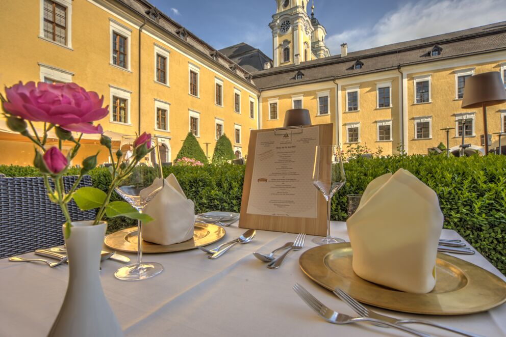 A laid table in the Culinaro restaurant at Mondsee - with flowers and a menu for the guests