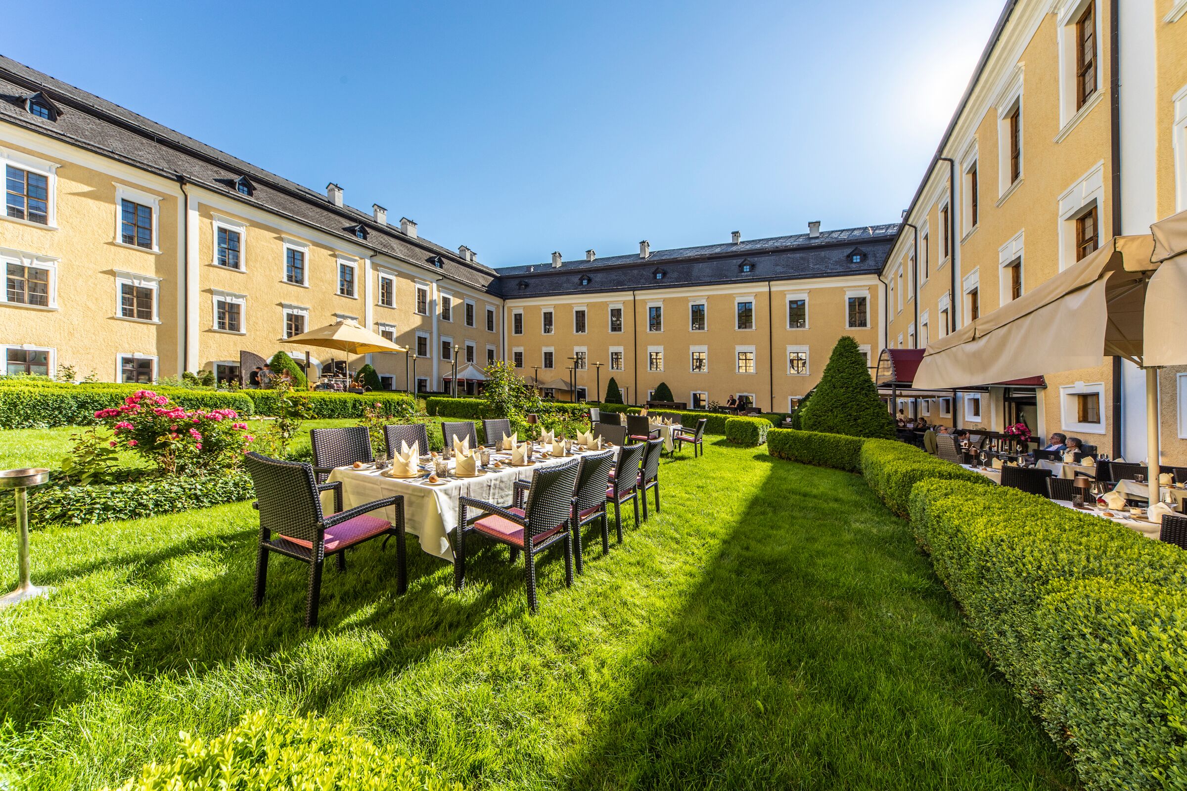 Eine festlich gedeckte Tisch mitten im Schlossgarten des Schlosshotels Mondsee im Salzkammergut