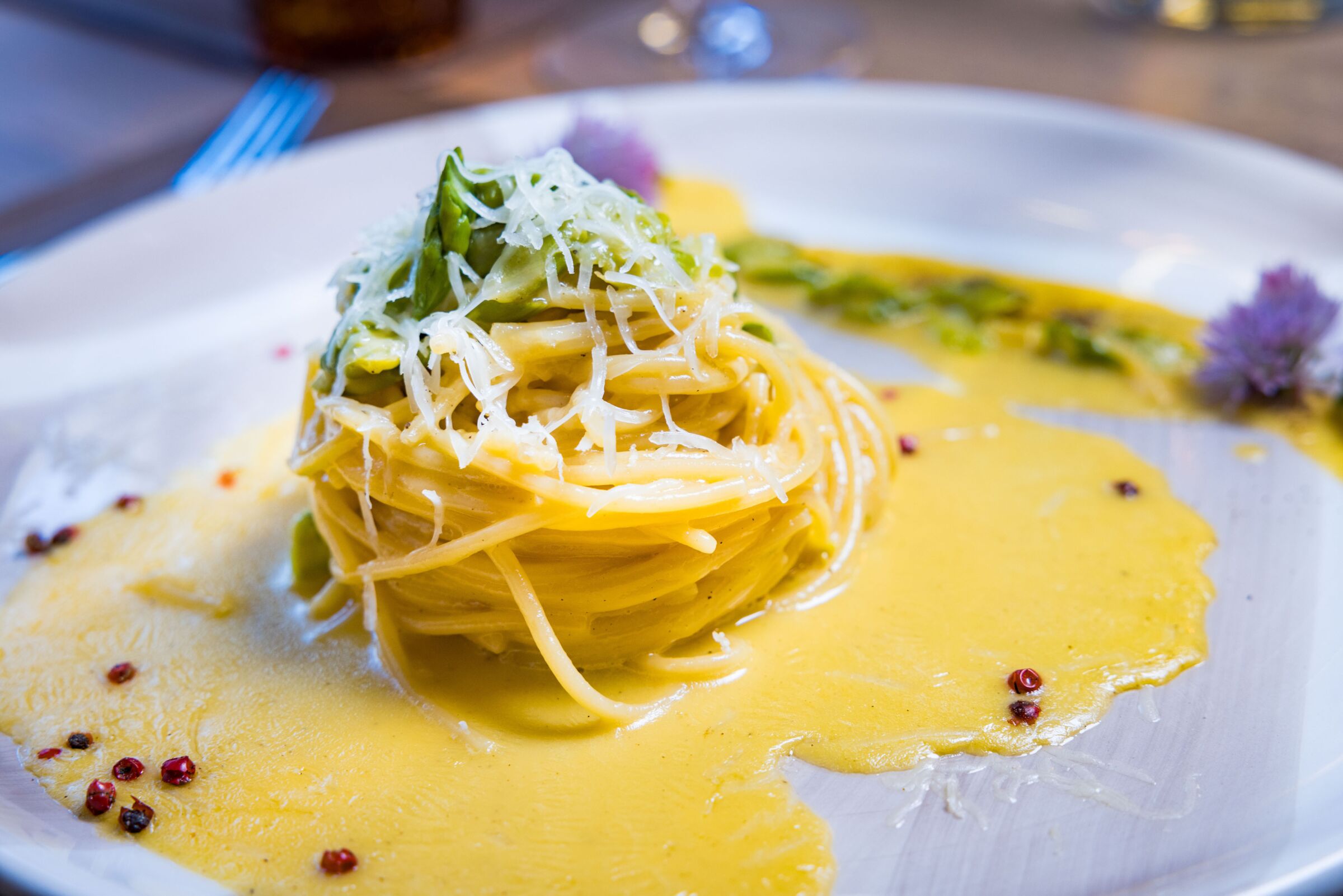 Tagliatelle mit Spargel und Käse auf grauem Teller